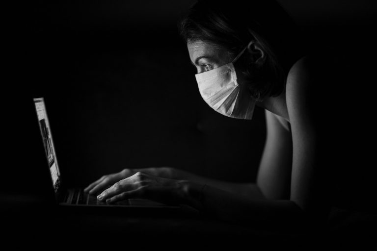 woman wearing a mask in from on the PC